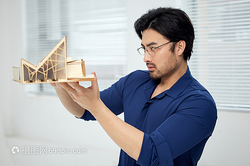建筑設計師手拿建筑模型研究